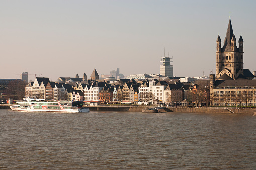 Cologne, Germany - February 29, 2016: View across Rhine river onto St. Martins church (on the right hand) and old town district with historic buildings