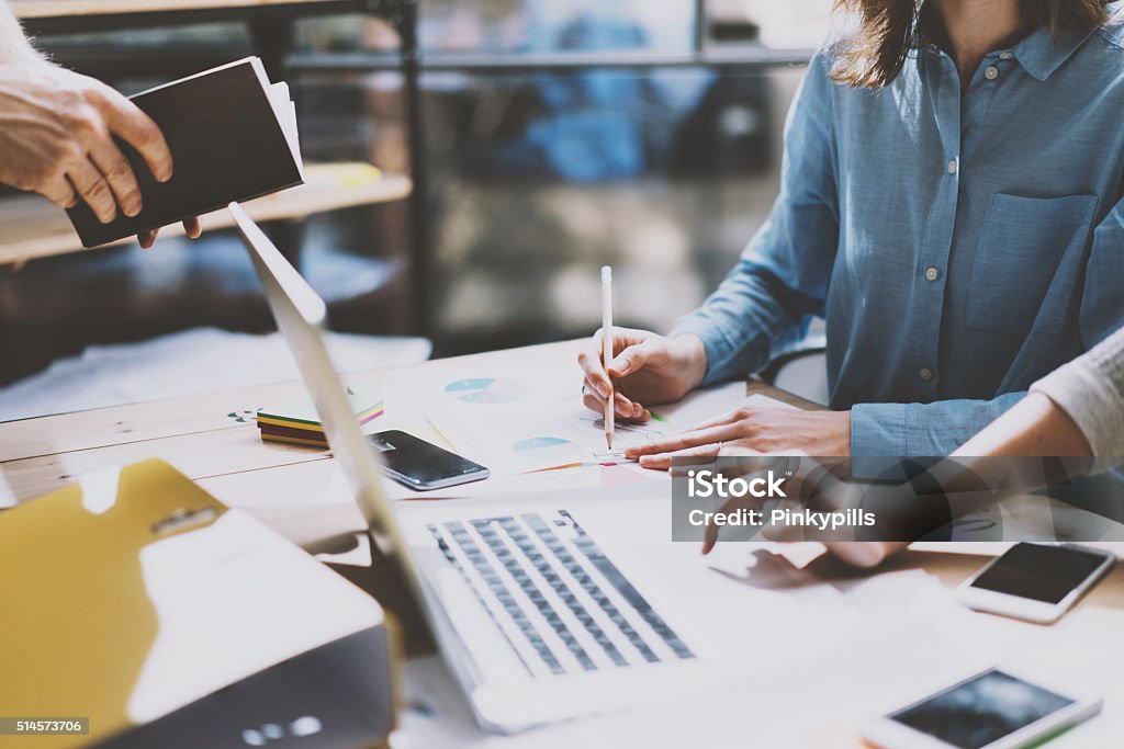 Teamwork. Photo young businessmans crew working with new startup project Team succes. Photo young businessmans crew working with new startup project. Generic design notebook on wood table.  Analyze plans hands, keyboard. Design Professional Stock Photo