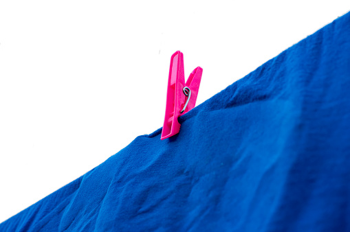 Clothsping on blue cloth hanging on a string