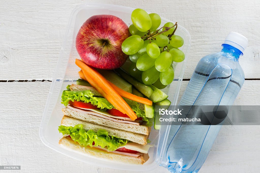 Lunchbox with sandwich, vegetables and fruit, bottle of water Lunchbox with sandwich, vegetables and fruit, bottle of water on a white background Bag Stock Photo