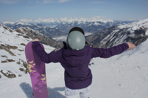 Young woman on the Kaprun, skiing resort in Austria. A view from the back.