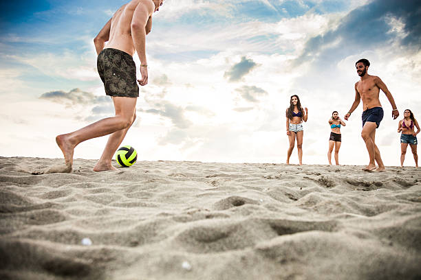 istock Friends playing soccer during vacations on the beach 514579344