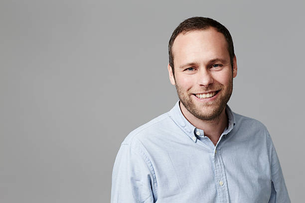 hombre de mediana edad sonriendo en estudio - desabrochado fotografías e imágenes de stock