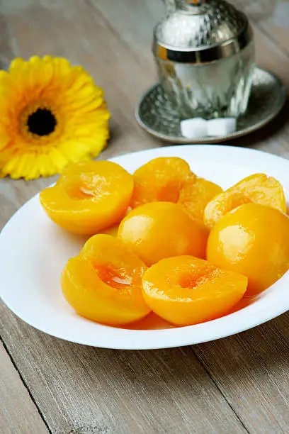 Peaches on the white dish, gerber and sugar-bowl