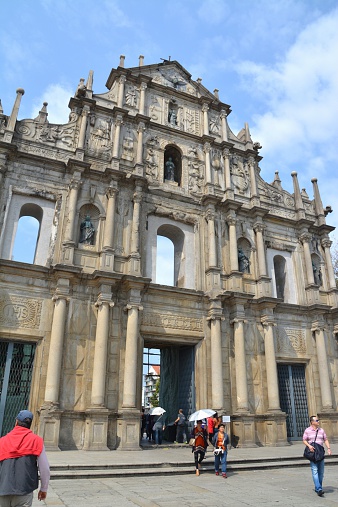 Macau, Macau - March 24, 2014: Cathedral of St, Paul's facade ruins is Macau's main landmark. The cathedral was once one of the largest Catholic churches in Asia. Some tourists sightseeing and taking pictures with the ruins.
