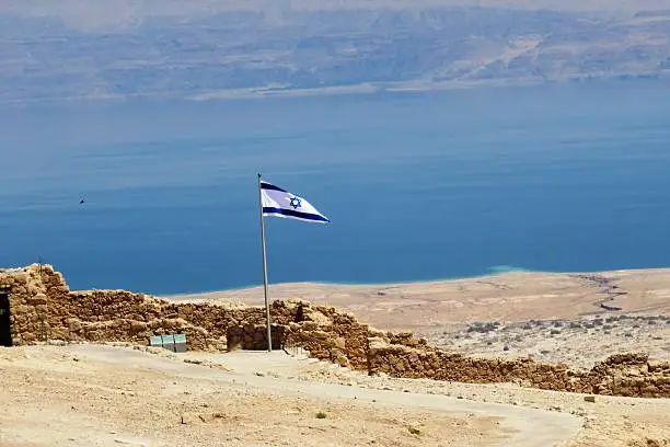 Israel flag as viewed from Masada, Dead Sea in the back