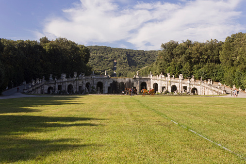 Caserta, Italy, August 14, 2014: Caserta Royal Palace garden. The park is a typical exemplar of the Italian garden, landscaped with vast fields, flower beds and, above all, a triumph of “water games” or dancing fountains