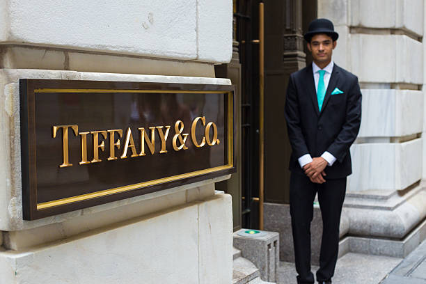 Tiffanys New York City New York City, New York, USA - August 3, 2014: View of Tiffany & Co. Building on Wall Street in the Financial District in Manhattan with doorman.  Tiffany's is a luxury American multinational jewelry and silverware corporation. door attendant photos stock pictures, royalty-free photos & images