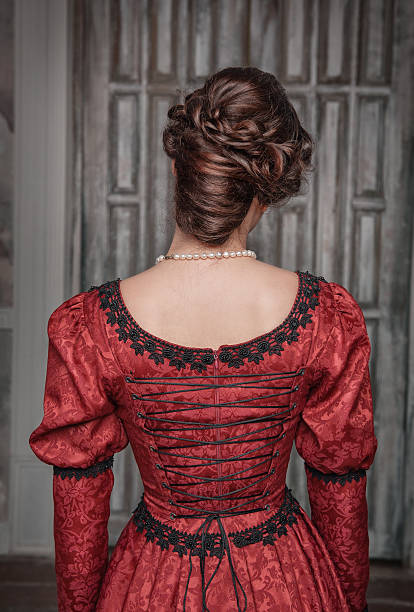 Beautiful medieval woman in red dress, back stock photo