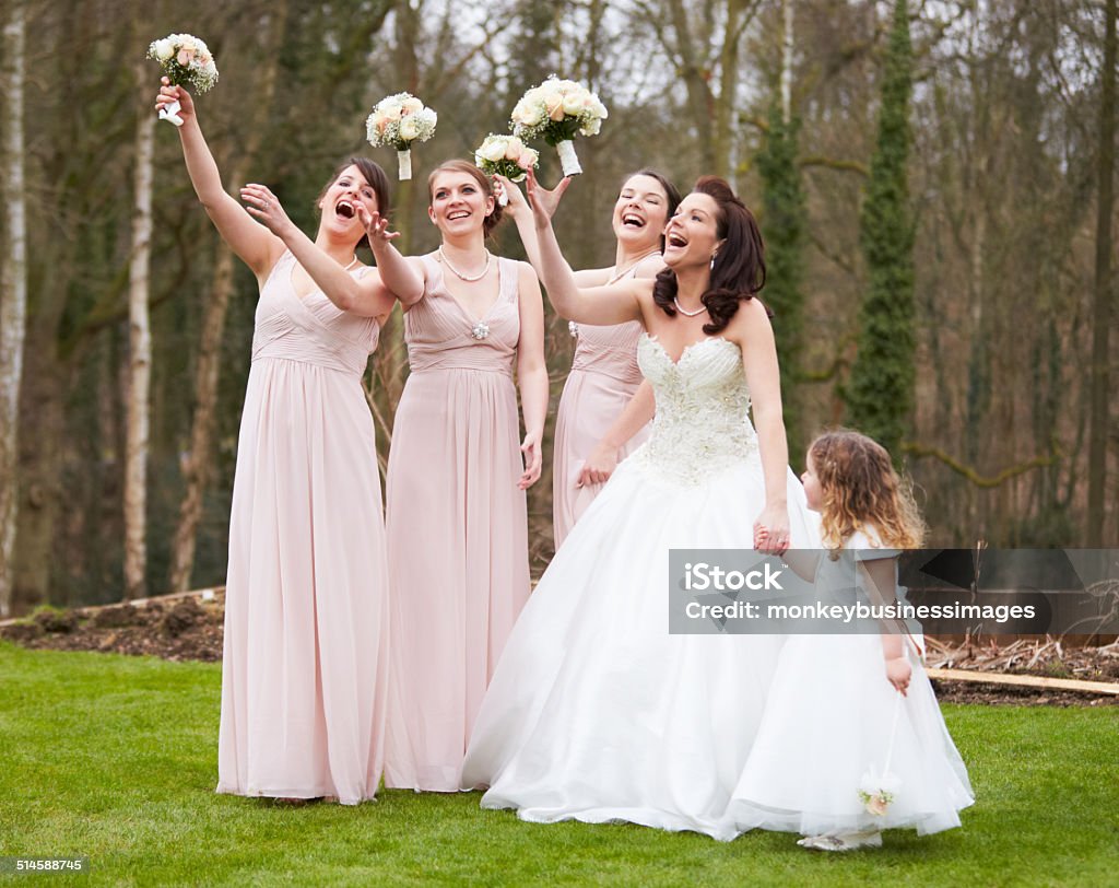 Bride With Bridesmaids On Wedding Day Bride With Bridesmaids On Wedding Day Throwing Flowers In The Air Bridesmaid Stock Photo