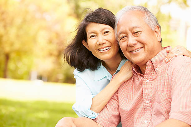 portrait de senior couple asiatique détente dans le parc ensemble - senior adult human face male action photos et images de collection