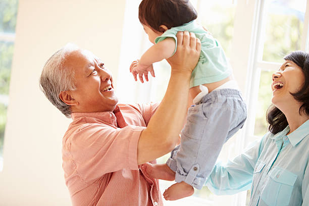 Grandparents And Grandson Playing Game Indoors Together Grandparents And Grandson Playing Game Indoors Together Holding Grandson In The Air old man baby stock pictures, royalty-free photos & images
