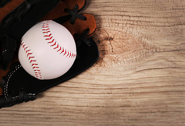 istock Baseball. Ball in Glove over wood background 514611337