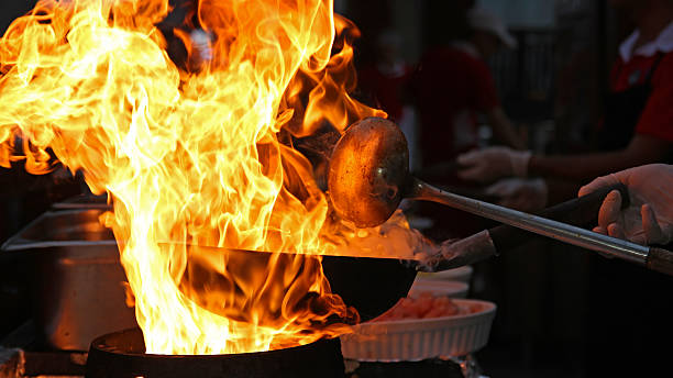 chef cocina con fuego en sartén - wok fotografías e imágenes de stock