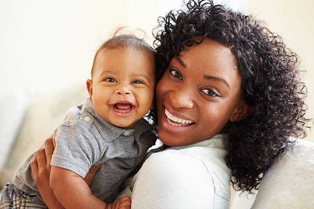 Smiling Mother Playing With Baby Son At Home Smiling Mother Playing With Baby Son At Home Looking To Camera mom and baby eye contact stock pictures, royalty-free photos & images
