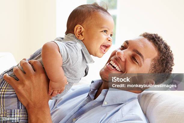 Smiling Father Playing With Baby Son At Home Stock Photo - Download Image Now - Baby - Human Age, Father, Family