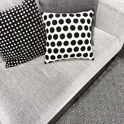 Black and white polka dot cushions on a sofa. Stylish modern furniture.