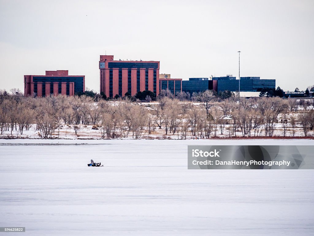 Urban Ice Fishing, City Backdrop Ice fishing setup with buildings in background; urban setting Activity Stock Photo
