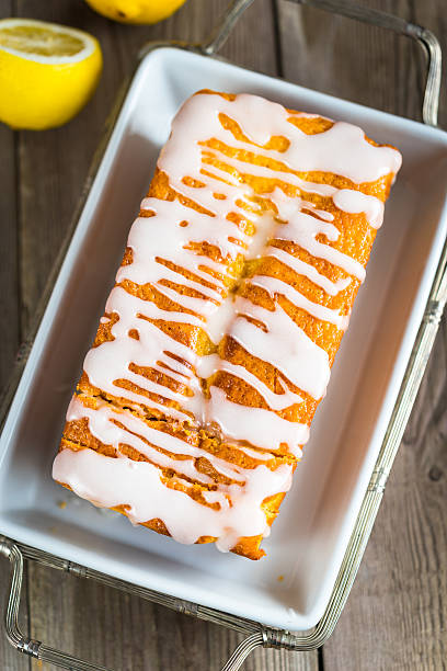 Lemon yogurt loaf cake, sliced on a creative plate on wooden background for your design