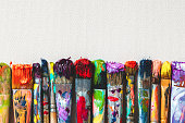 istock Row of artist paintbrushes closeup on canvas. 514627514