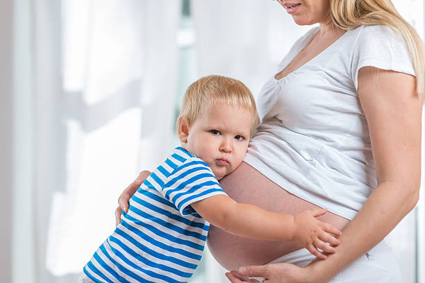 istock Kid boy hugging pregnant mother's belly 514628078