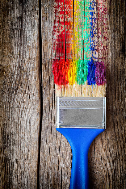 istock Paintbrush and multicolor rainbow brush strokes on wooden board 514628418