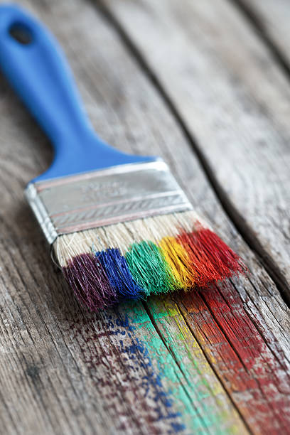 istock Paintbrush and multicolor rainbow brush strokes on wooden plank. 514628536