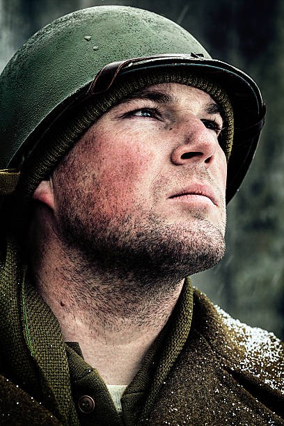 Pensive, young World War 2 soldier with winter helmet looking toward the future.