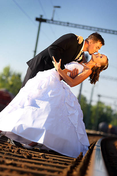 istock Young wedding couple kissing on railway 514629224
