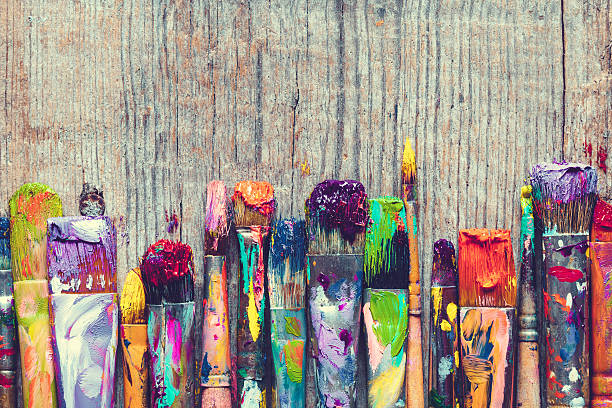 Row of artist paint brushes closeup on old wooden background. stock photo