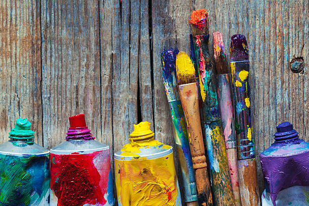 Tubes of oil paint and artist paint brushes closeup Tubes of oil paint and artist paint brushes closeup on wooden background. Retro styled. drawing artistic product stock pictures, royalty-free photos & images
