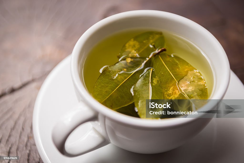 Coca tea infusion in white mug Andean South American coca tea leaves infused in white mug and saucer Ecuador Stock Photo