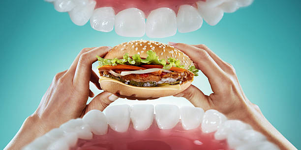 istock Diet. Tasty burger in the hands. View from mouth 514642092