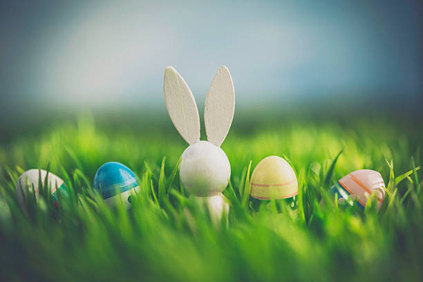 istock Vintage wooden bunny with Easter eggs in grass 514642198