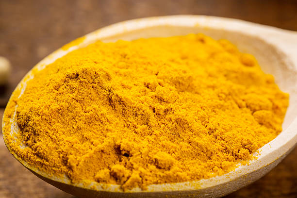 istock measuring spoon in pile of organic turmeric 514643258
