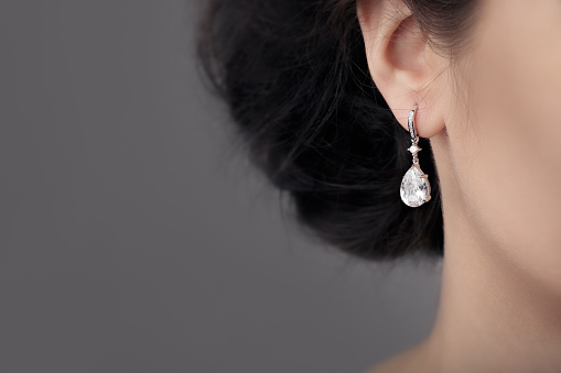 Image of a beautiful precious piece of jewel hanging from ear 