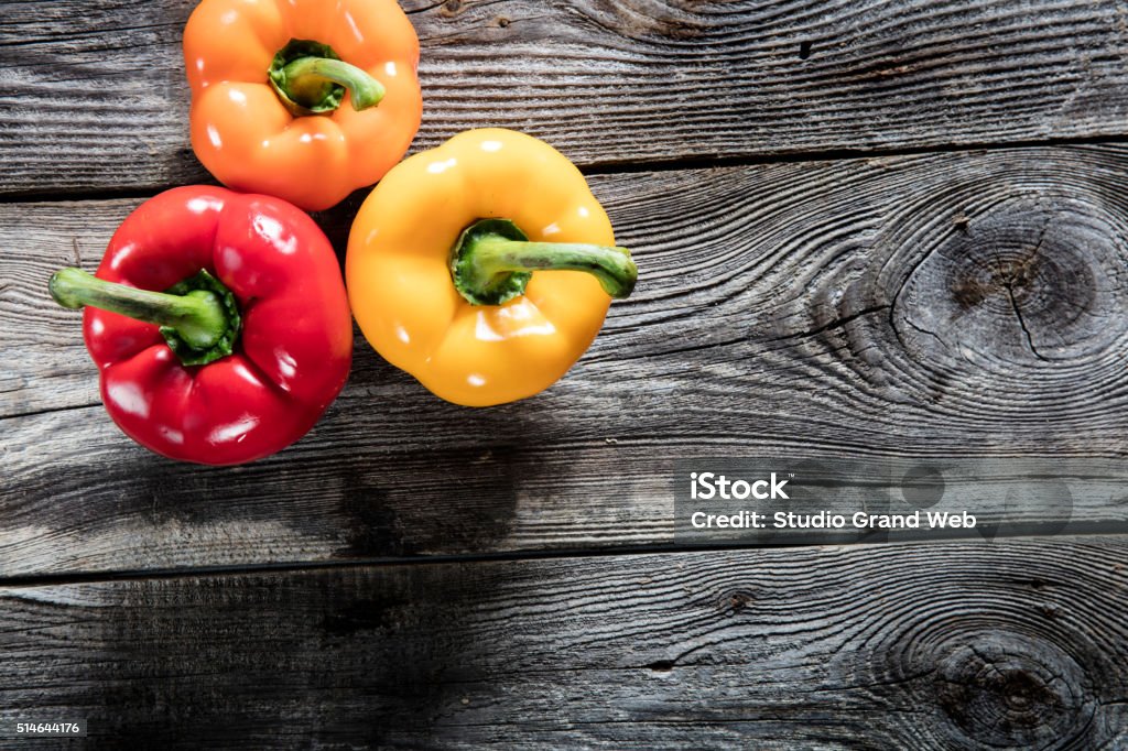 colorful bell peppers on authentic old wood copy space vegetable still life - variety of colorful bell peppers on authentic old wooden background or barn table for vegetarian diet, studio shot, top view Bell Pepper Stock Photo