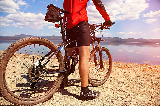 istock man with bike on a mountain lake 514646322