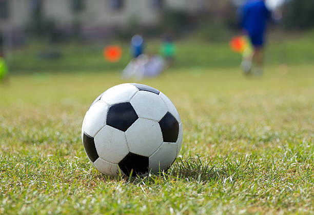 istock Soccer ball on the grass and coach children 514647384