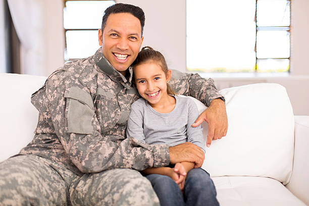 istock military father sitting on the couch with his daughter 514647680