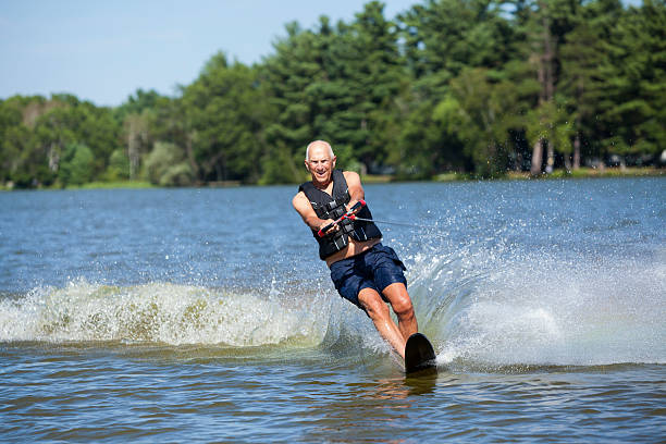 uomo anziano slalom di sci d'acqua sul lago in estate - water ski foto e immagini stock