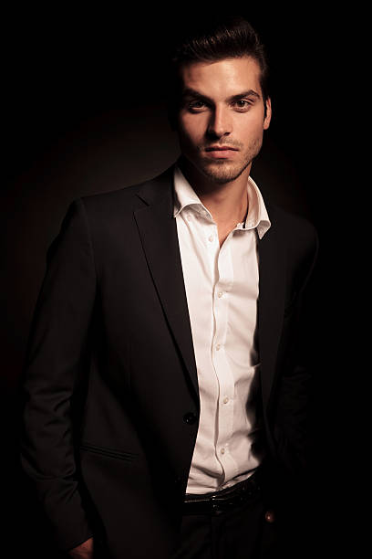 istock business man with hands in his pockets on dark background 514653739