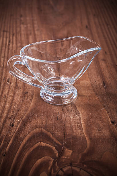 istock empty transparent glass sauce-boat on old wooden board 514654459