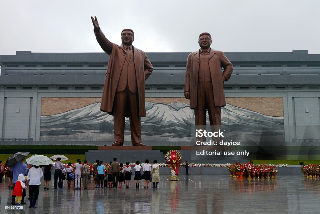 Grand Monument in Pyongyang, North Korea Pyongyang, North Korea - August 15 2012: North Koreans showing their respect to their political leaders at the Grand Monument on Mansu Hill with the bronze statues of Kim II Sung and Kim Jong II. North Korea Stock Photo