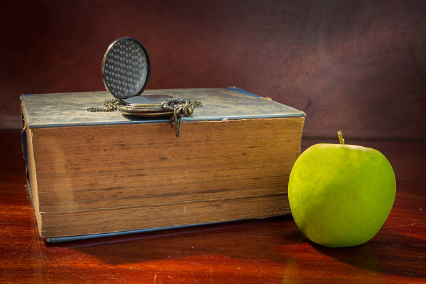 istock Green apple with antique book and watch. 514655009