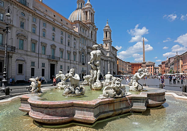 Moor Fountain, Piazza Navona, Rome, Italy Piazza Navona is a city square in Rome, Italy. It is built on the site of the Stadium of Domitian, built in 1st century AD. Piazza Navona became with time a highly significant example of Baroque Roman architecture and art during the pontificate of Innocent X, who reigned in from 1644 until 1655 and whose family palace, the Palazzo Pamphili, faced the piazza. It features important sculptural and architectural creations: such as here the Fontana del Moro (Moor Fountain), a fountain located at the southern end of the Piazza Navona. It represents a Moor, or African (perhaps originally meant to be Neptune), standing in a conch shell, wrestling with a dolphin, surrounded by four Tritons. It is placed in a basin of rose-colored marble. fontana del moro stock pictures, royalty-free photos & images
