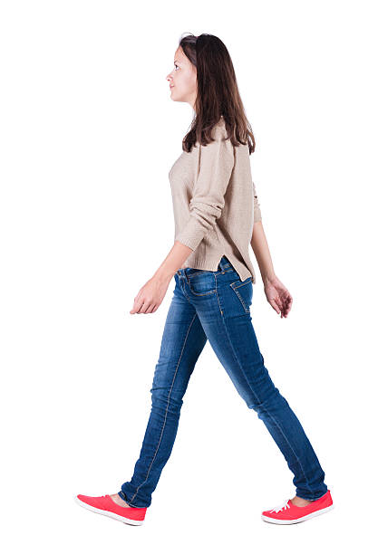 back view of walking woman in jeans . back view of walking woman in jeans . beautiful brunette girl in motion. backside view of person. Rear view people collection. Isolated over white background. The girl in a striped T-shirt with sleeves podkatannymi goes ahead pics of girls buttocks stock pictures, royalty-free photos & images