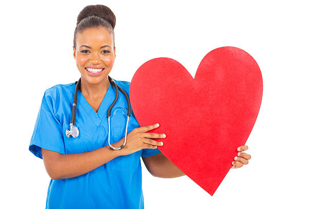 african american healthcare worker with heart symbol attractive african american healthcare worker with heart symbol red medical scrubs stock pictures, royalty-free photos & images