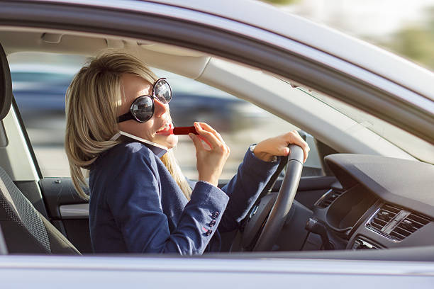 Woman talks on phone and does makeup while driving car