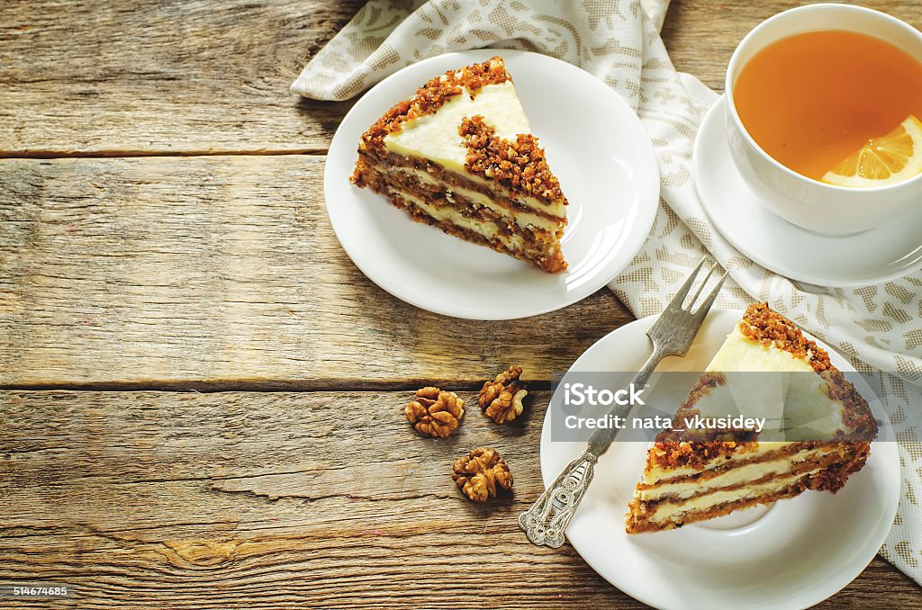 carrot cake with raisins, walnuts and butter cream carrot cake with raisins, walnuts and butter cream on a dark wood background. tinting. selective focus on the bottom cake Autumn Stock Photo